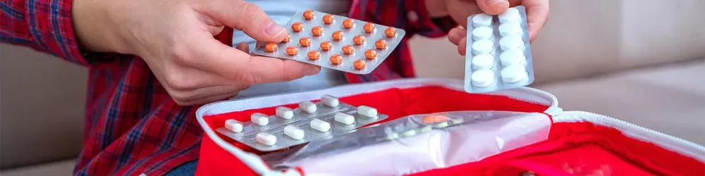 Person packing medication for travel